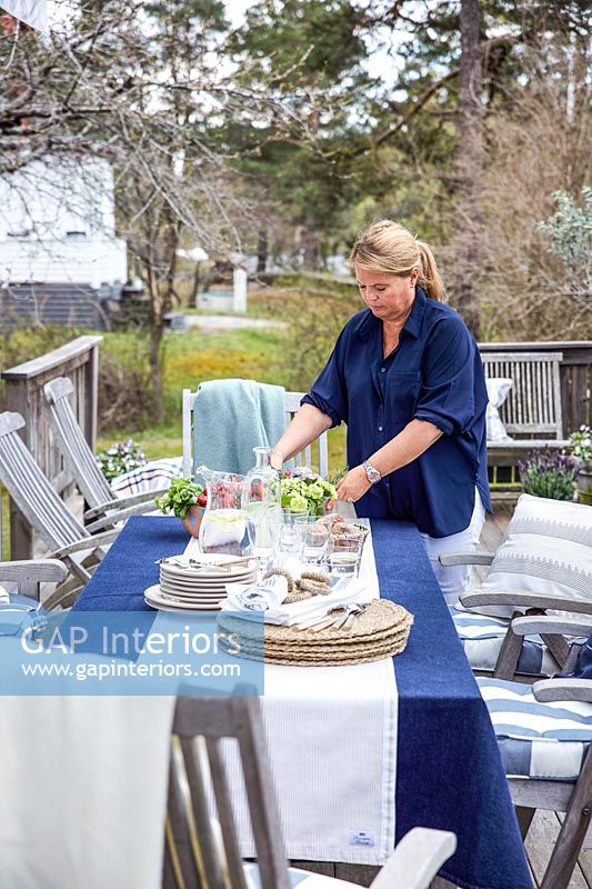 Woman preparing outside dining table for entertaining