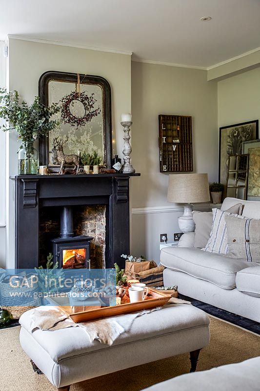 Country living room with lit wood burning stove in fireplace 