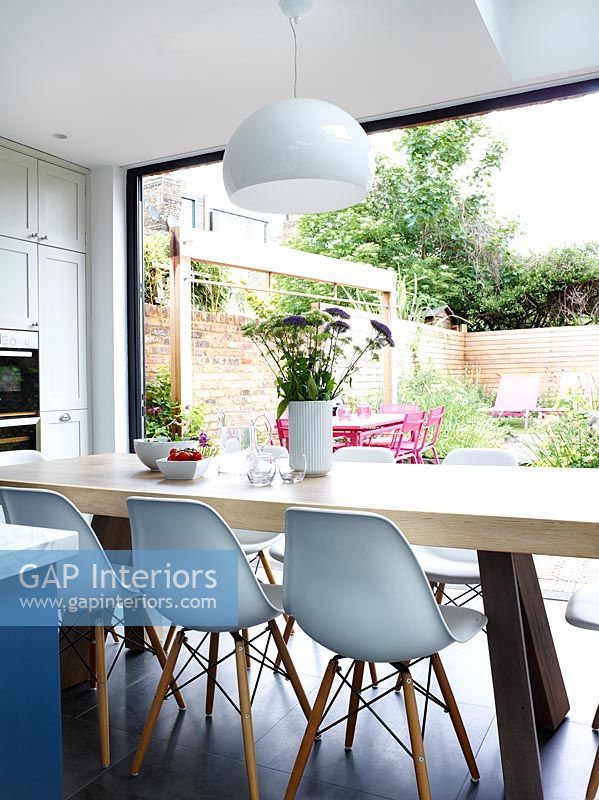 Large dining table in modern kitchen overlooking garden 