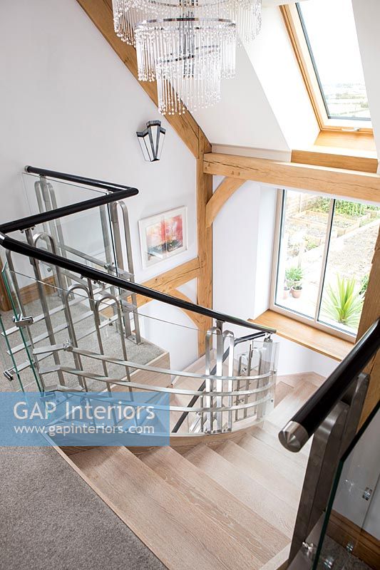 View down modern staircase with exposed wooden beams 