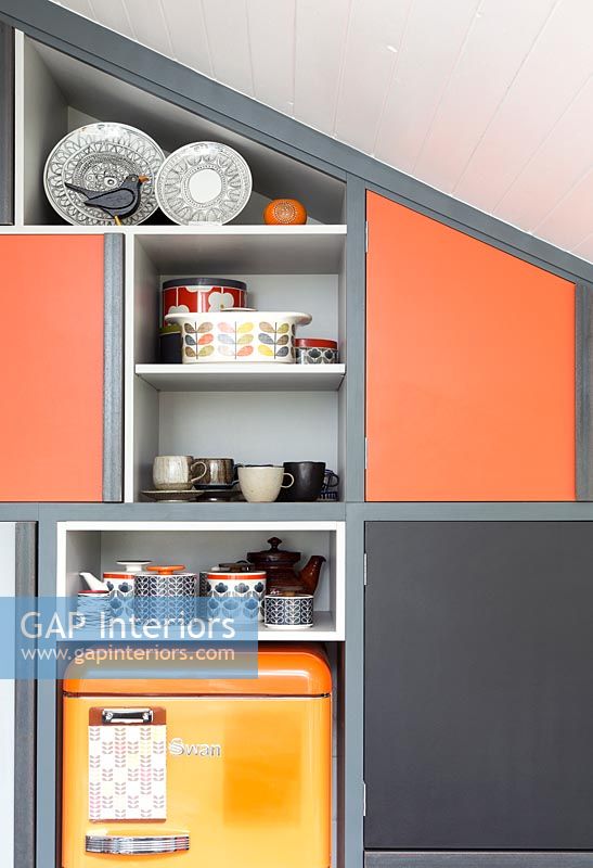 Built-in cabinets and shelve with different coloured doors 