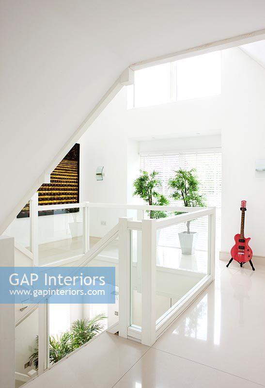 Bright red electric guitar in white contemporary hallway 
