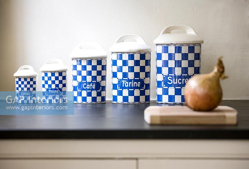 Row of blue and white storage jars on kitchen worktop 