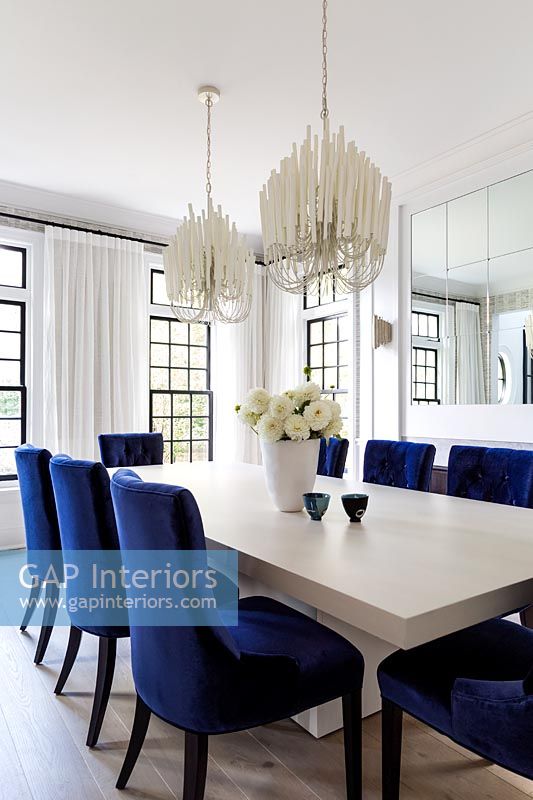 Black and white dining room with blue upholstered chairs 