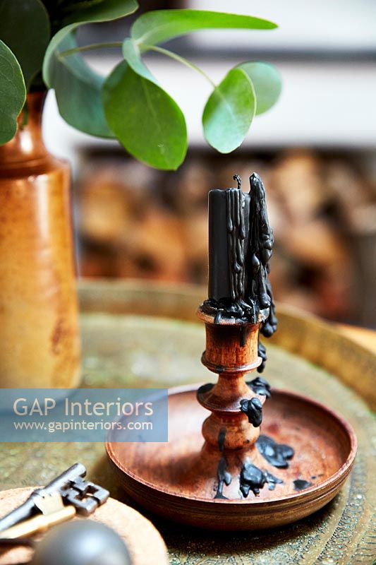 Melted black candle in wooden candle holder 