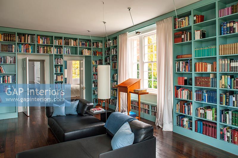 Wall to wall painted wooden bookcases in classic library 