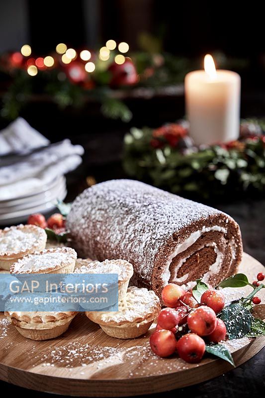 Christmas yule log and mince pies on table