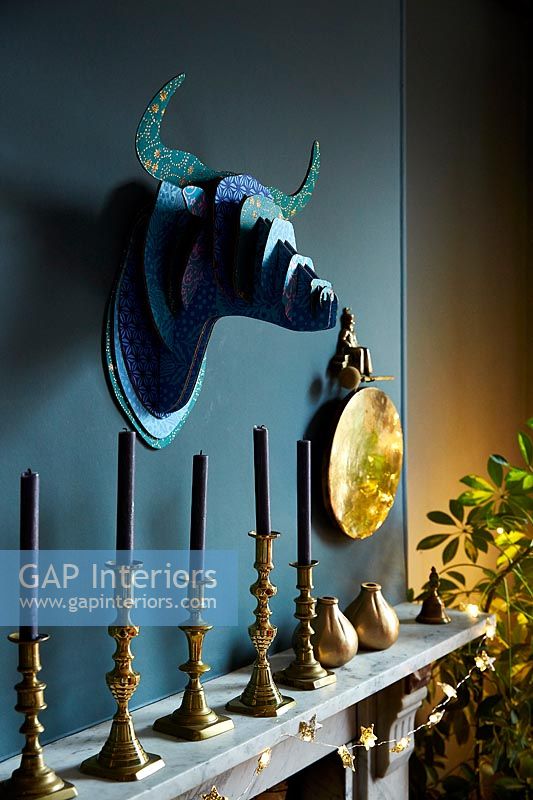 Decorative trophy head and candles over fireplace 