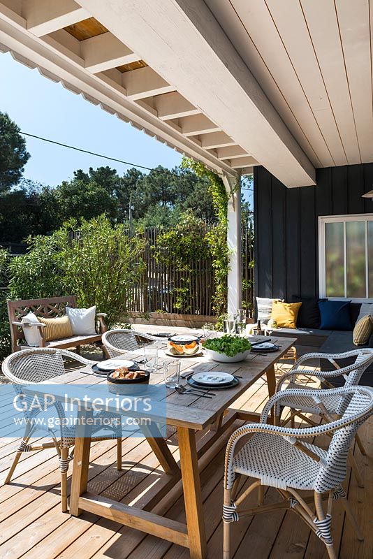 Outdoor living and dining area on decked terrace, summer 
