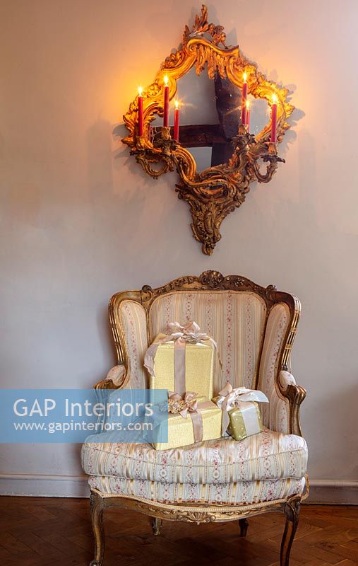 Ornate chair and mirror with Christmas gifts 