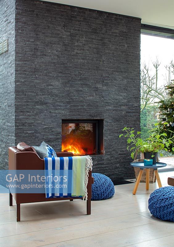 Slate wall with lit fireplace in modern living room 