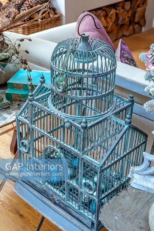 Decorative blue bird cage with Christmas baubles inside 