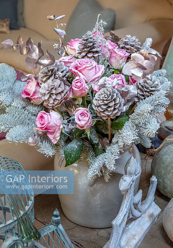 Christmas decoration with dried pink roses and silver sprayed foliage 