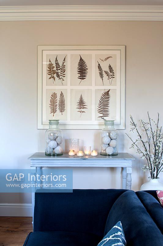Painting of ferns above table decorated with candles 