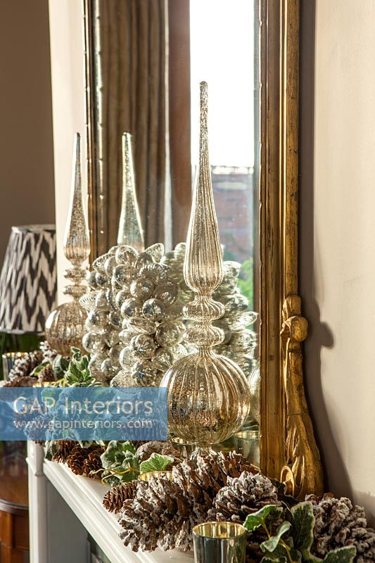 Vintage glassware and Christmas decorations on mantelpiece 
