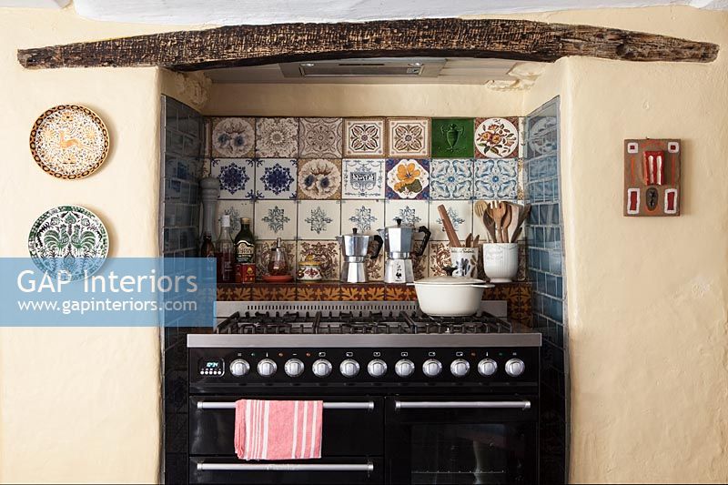 Large range cooker in country kitchen with decorative tiling 