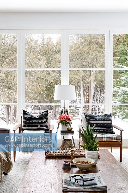 Wooden armchairs by large windows in winter