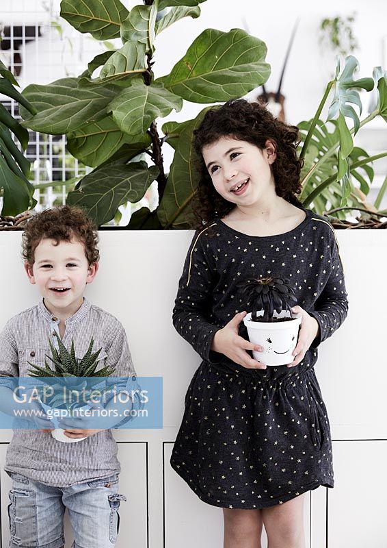 Children holding plant pots