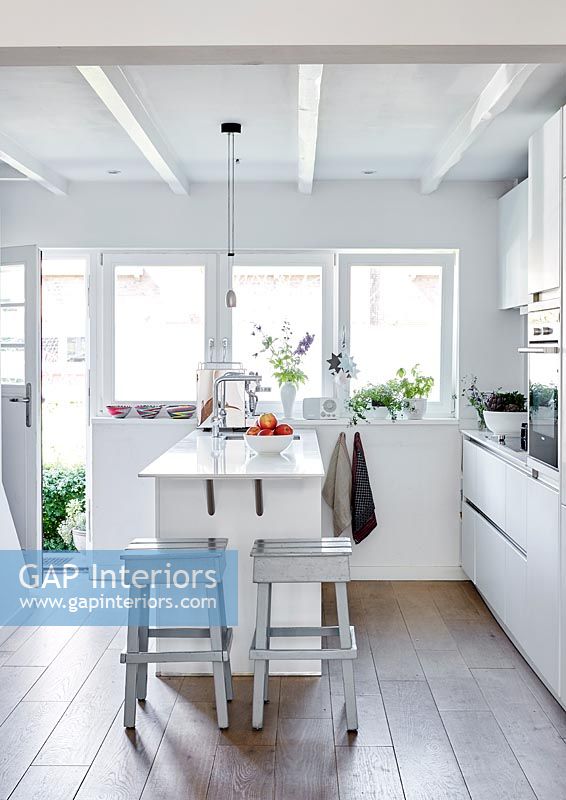 Modern white kitchen with wooden flooring 