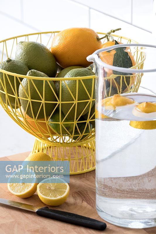Lemons and limes in yellow fruit basket 