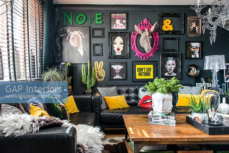 Eclectic living room with black painted walls and modern artworks