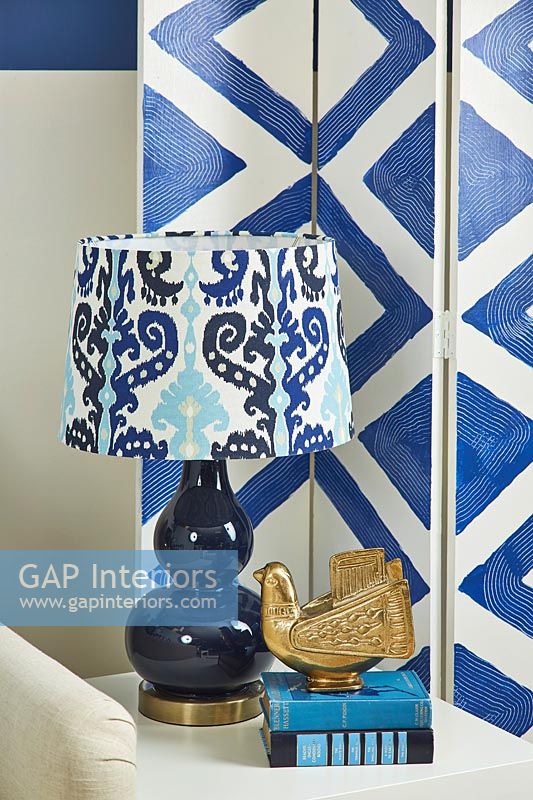 Blue and white privacy screen and patterned lamp on side table 