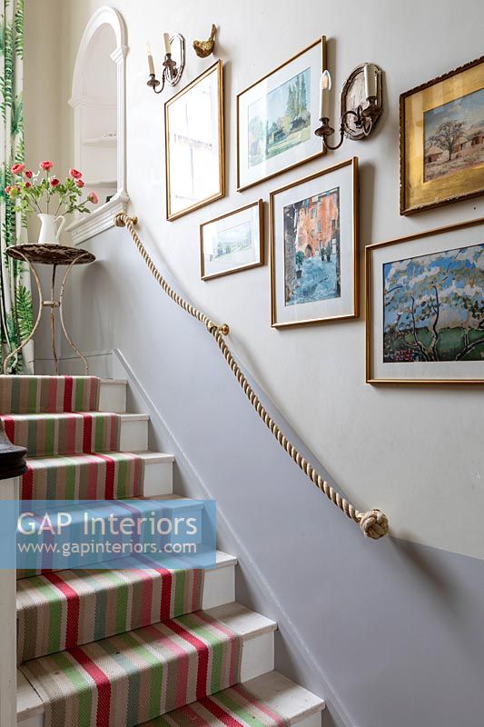 Striped runner carpet up stairs in country house