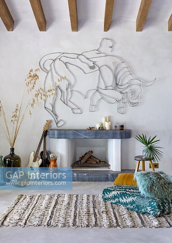 Fireplace with Bull sculpture on wall, guitars and rug - modern country living room