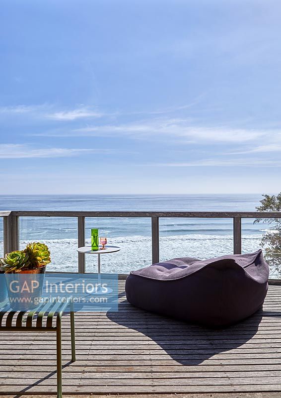 Large beanbag recliner on decked balcony overlooking sea 