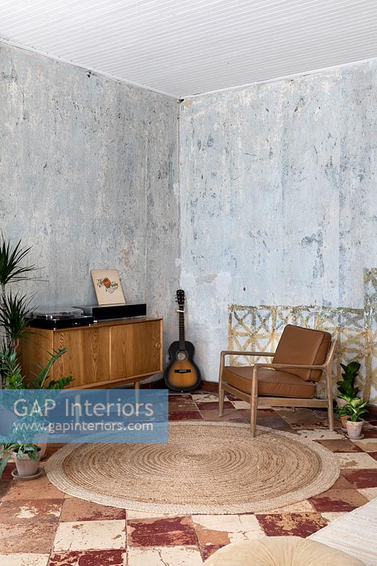 Living room with vintage furniture and bare plaster walls 