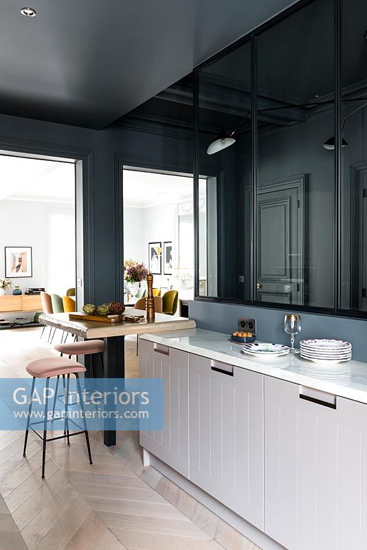 Modern kitchen with dark grey painted walls and parquet flooring 