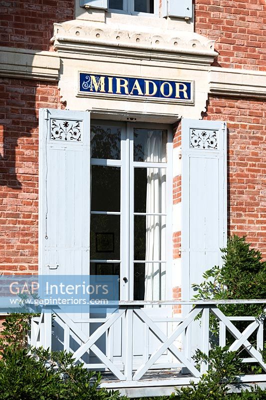 Mirador written over French windows with shutters and balcony 