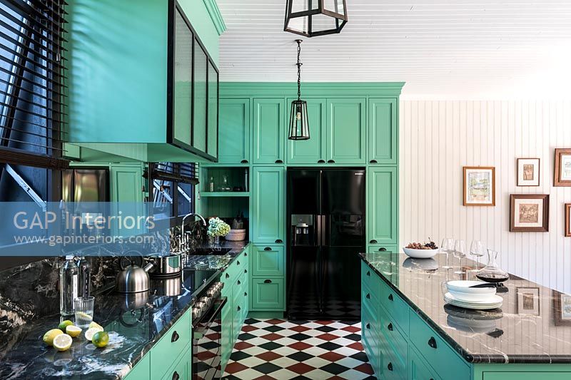 Bright green modern kitchen with red, white and black checkerboard flooring 
