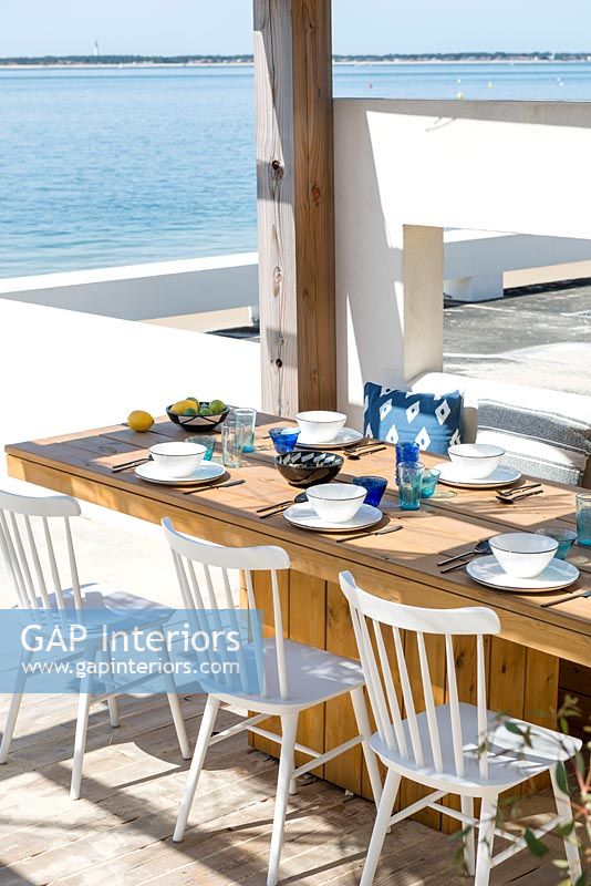 Built-in dining table on decking overlooking the sea 