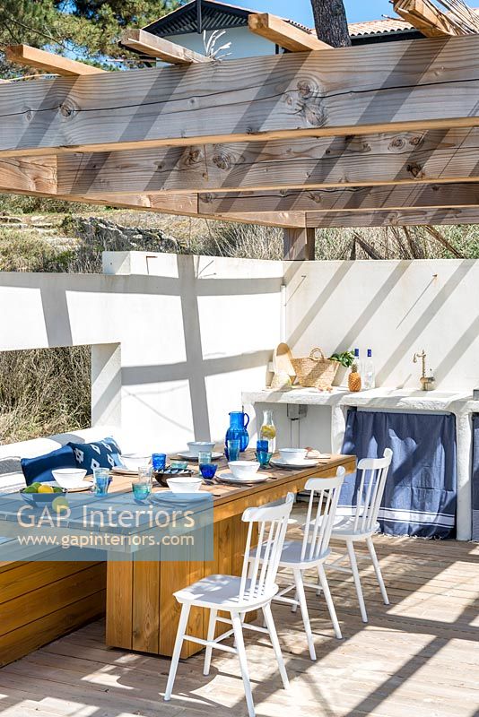 Walled dining area with outdoor kitchen on beach side terrace 