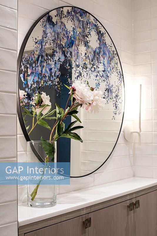 Decorative painted mirror and flowers in bathroom 