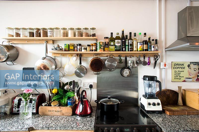 Modern kitchen with shelf of spices and cooking condiments 