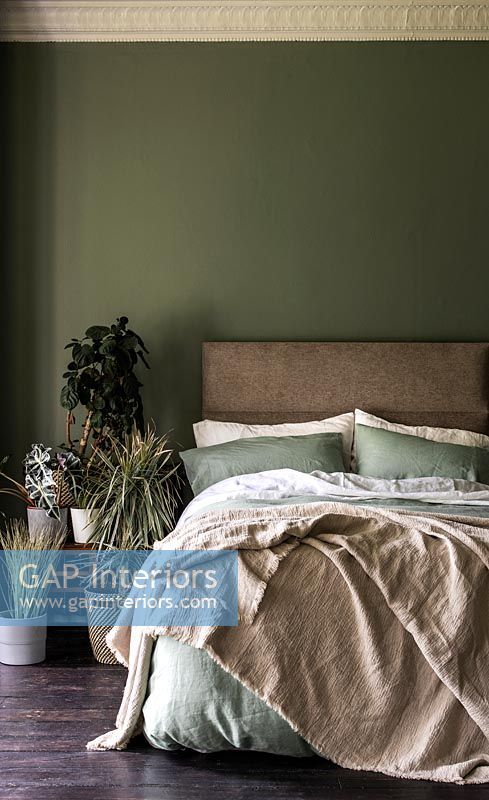 Country bedroom with dark green painted walls 