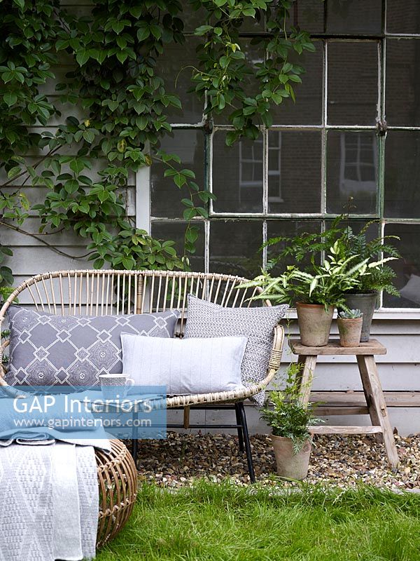 Wicker sofa in country garden 
