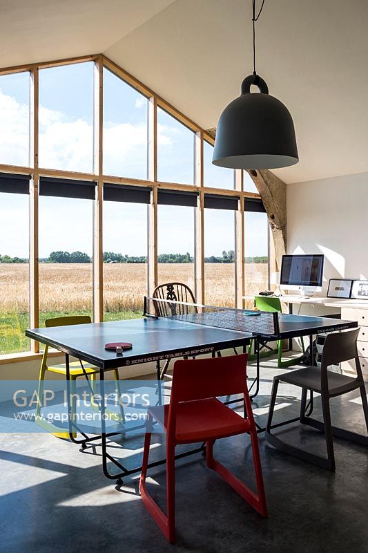 Modern dining room with glazed wall and views of countryside 