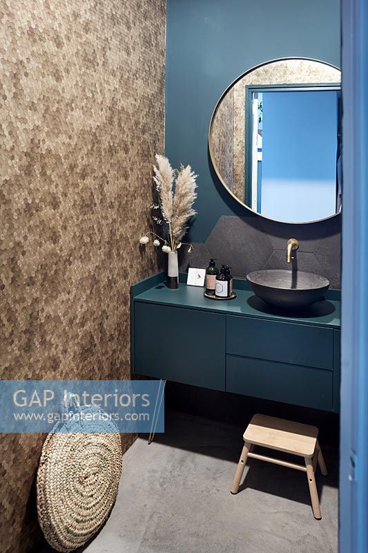 Blue painted bathroom with stone mosaic wall 
