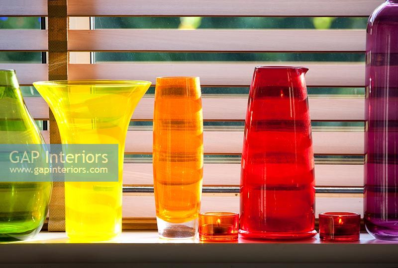 Colourful glassware on windowsill 