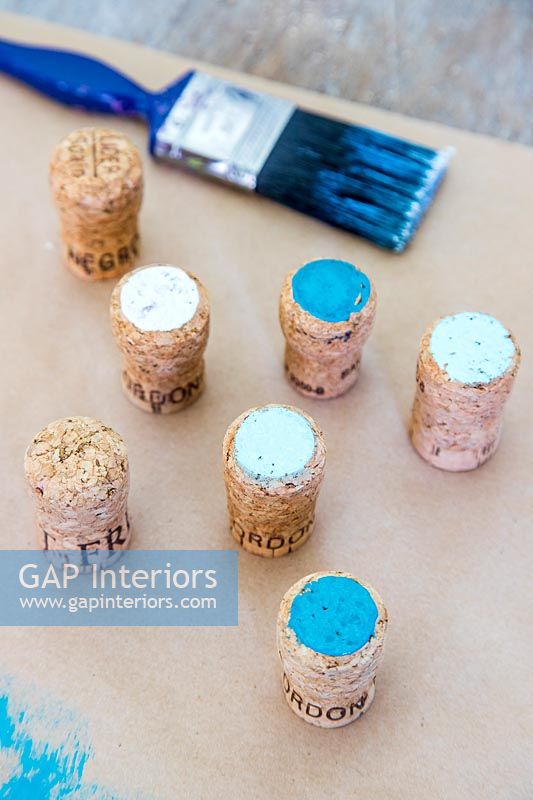 Painted corks next to brush
