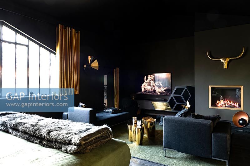 Modern bedroom with black painted walls, television and fireplace 
