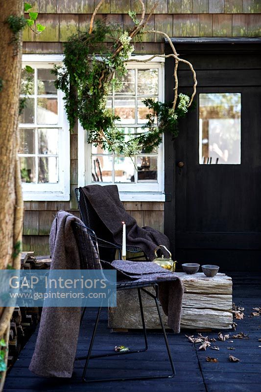 Chairs and low rustic table outside country house 