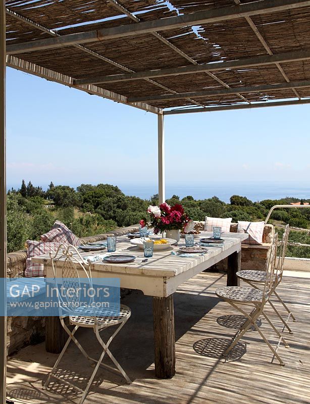 Outdoor dining table on wooden terrace with coastal views 