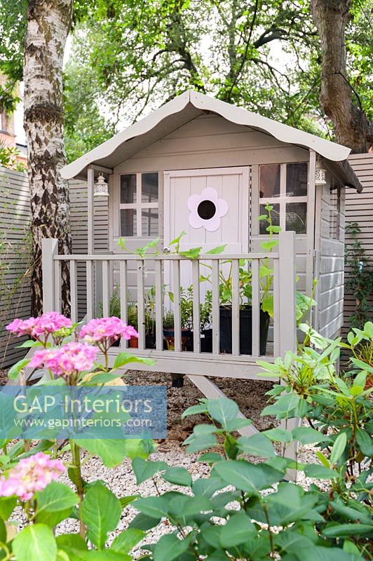 Decorative painted wooden playhouse in garden