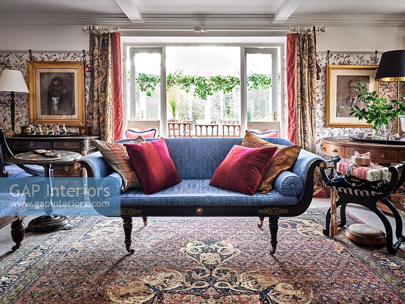 Classic living room with patterned wallpaper and antique furniture 