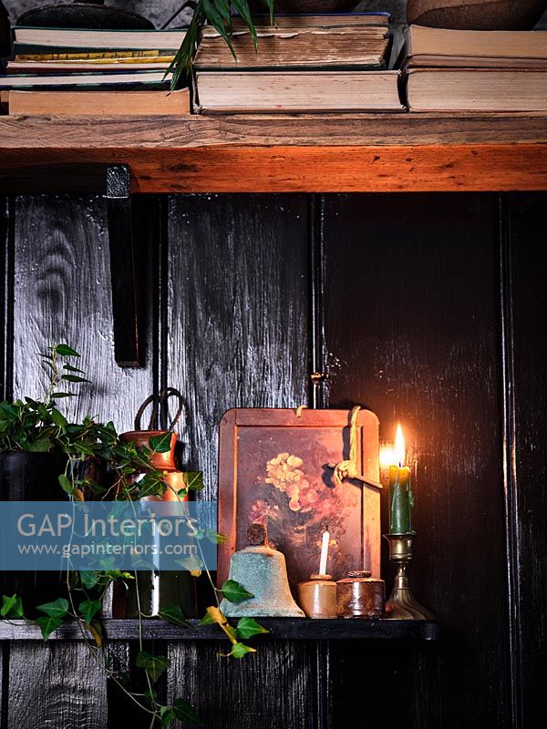 Country kitchen shelves with lit candle at Christmas time 