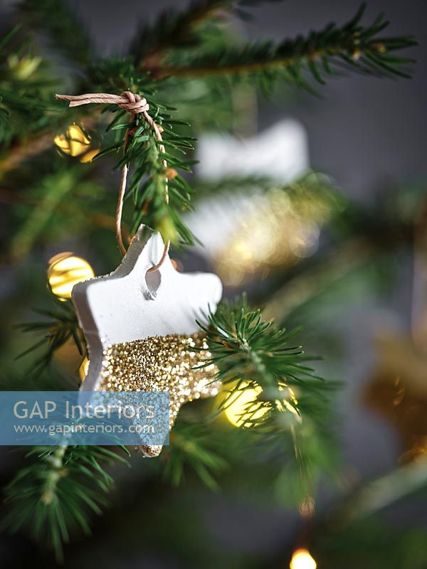 White and gold ceramic star on Christmas tree 